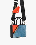 Bag with denim shoulder strap and orange accessory